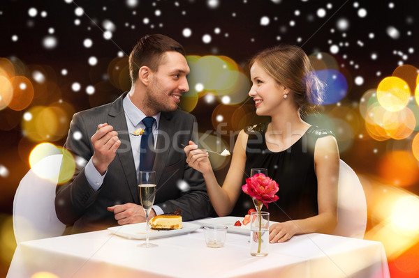 smiling couple eating main course at restaurant Stock photo © dolgachov