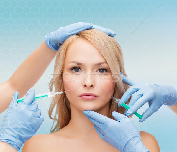 woman face and beautician hands with syringes Stock photo © dolgachov