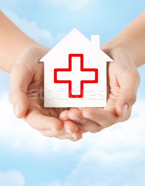 hands holding paper house with red cross Stock photo © dolgachov