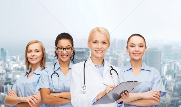 smiling female doctor and nurses with stethoscope Stock photo © dolgachov