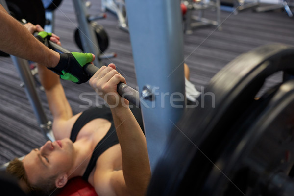 two young men with barbell flexing muscles in gym Stock photo © dolgachov