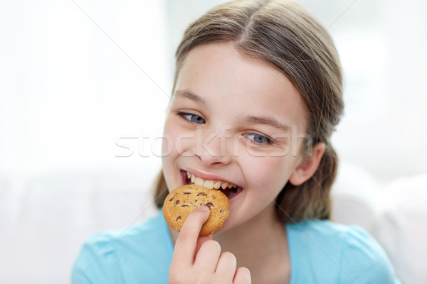 smiling little girl eating cookie or biscuit Stock photo © dolgachov
