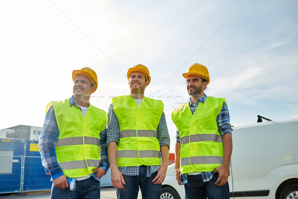 happy male builders in high visible vests outdoors Stock photo © dolgachov