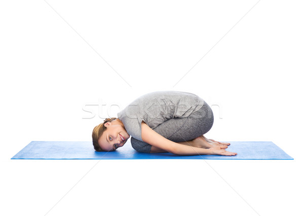 happy woman making yoga in child pose on mat Stock photo © dolgachov