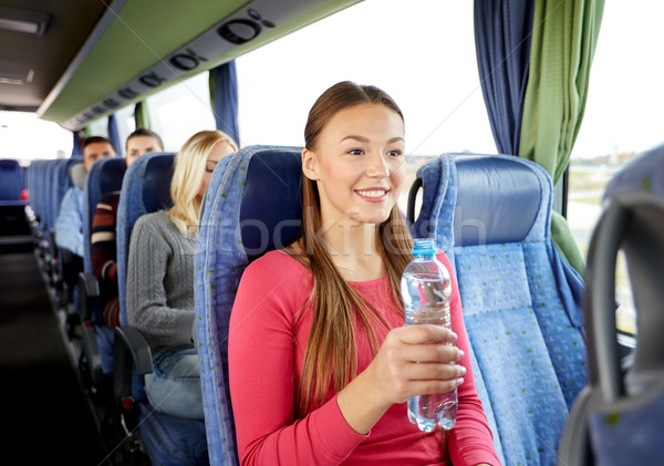 happy young woman with water bottle in travel bus Stock photo © dolgachov