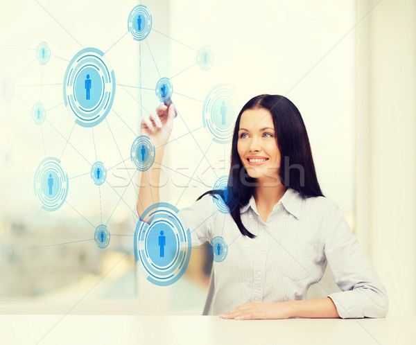 smiling woman writing on virtual screen Stock photo © dolgachov