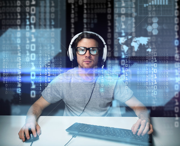 man in headset hacking computer or programming Stock photo © dolgachov