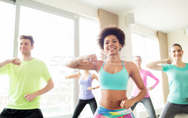 group of happy people exercising or dancing in gym Stock photo © dolgachov