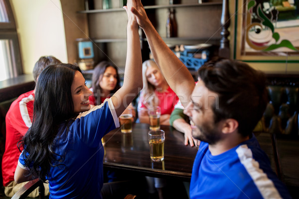 football fans with beer celebrating victory at bar Stock photo © dolgachov
