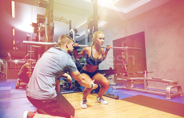 man and woman with bar flexing muscles in gym Stock photo © dolgachov