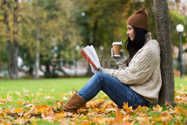 woman with book drinking coffee in autumn park Stock photo © dolgachov