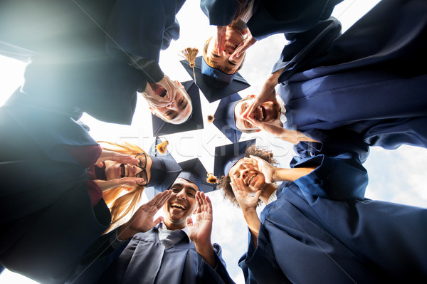 Stock photo: happy students or bachelors in mortar boards