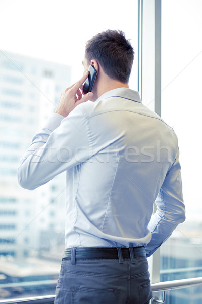 businessman calling on smartphone in office Stock photo © dolgachov
