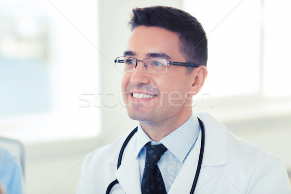 smiling male doctor in white coat and eyeglasses Stock photo © dolgachov