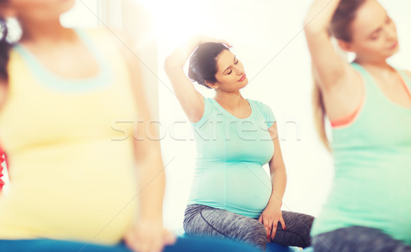 happy pregnant women exercising on fitball in gym Stock photo © dolgachov