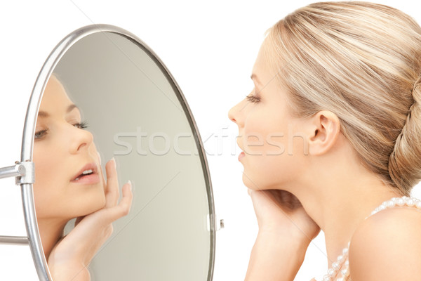 beautiful woman with pearl beads and mirror Stock photo © dolgachov