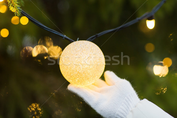 Közelkép kéz karácsonyfa girland villanykörte ünnepek Stock fotó © dolgachov