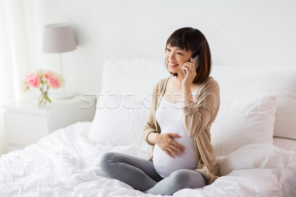 Heureux femme enceinte appelant smartphone maison grossesse [[stock_photo]] © dolgachov