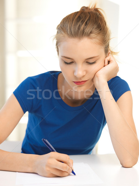 Stock photo: pensive teenage girl with pen and paper