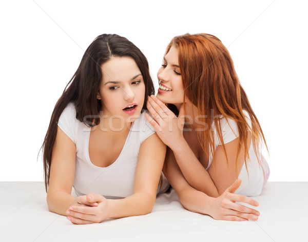 Deux souriant filles chuchotement potins amitié [[stock_photo]] © dolgachov