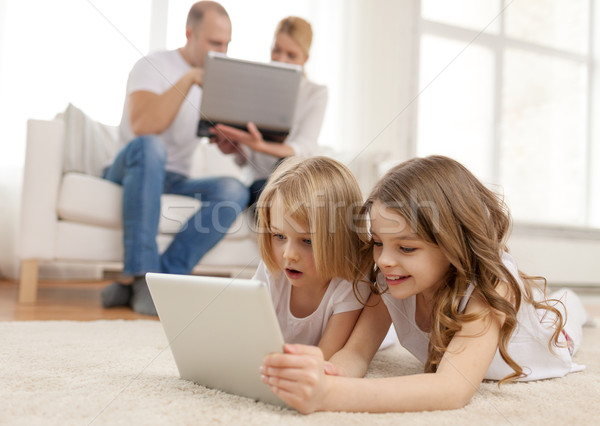 Stock photo: smiling sister with tablet pc and parents on back