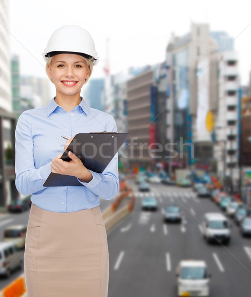 Sorridente empresária capacete clipboard edifício em desenvolvimento Foto stock © dolgachov