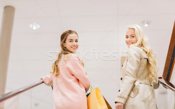 happy young women with shopping bags in mall Stock photo © dolgachov