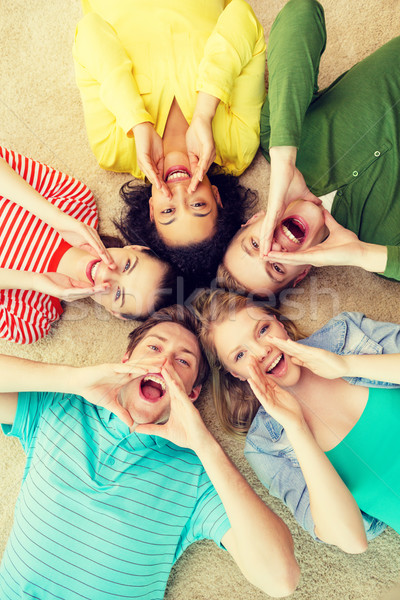 smiling people lying down on floor and screaming Stock photo © dolgachov