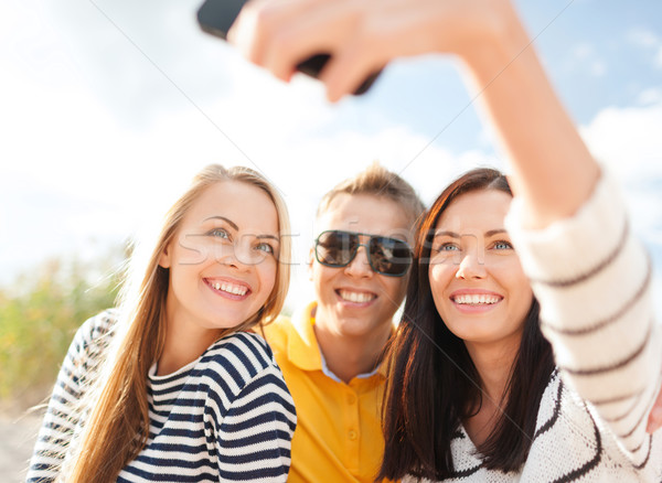 Stock photo: group of friends taking selfie with cell phone