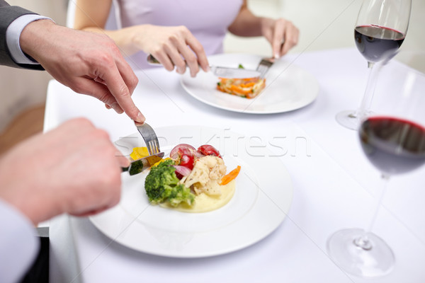 close up of couple eating appetizers at restaurant Stock photo © dolgachov