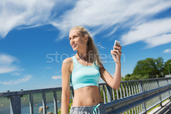 happy woman with smartphone exercising outdoors Stock photo © dolgachov