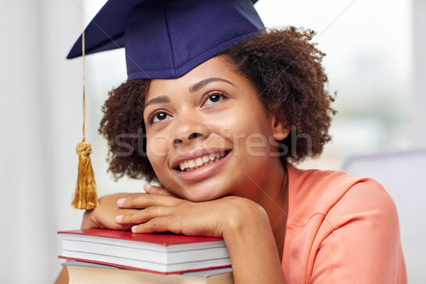 happy african bachelor girl with books at home Stock photo © dolgachov