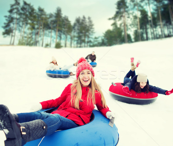 group of happy friends sliding down on snow tubes Stock photo © dolgachov