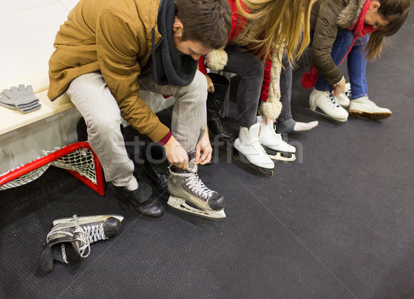 Stock photo: close up of friends wearing skates on skating rink