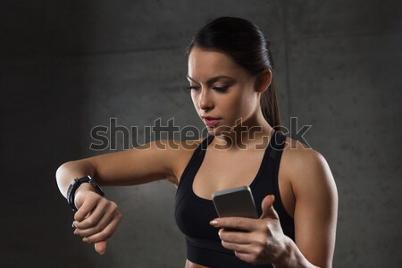 woman with heart-rate watch and smartphone in gym Stock photo © dolgachov
