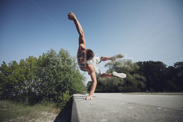 sporty young man jumping in summer park Stock photo © dolgachov