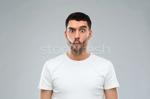 man with fish-face over gray background Stock photo © dolgachov