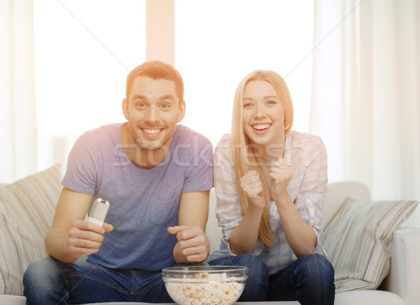 smiling couple with popcorn cheering sports team Stock photo © dolgachov