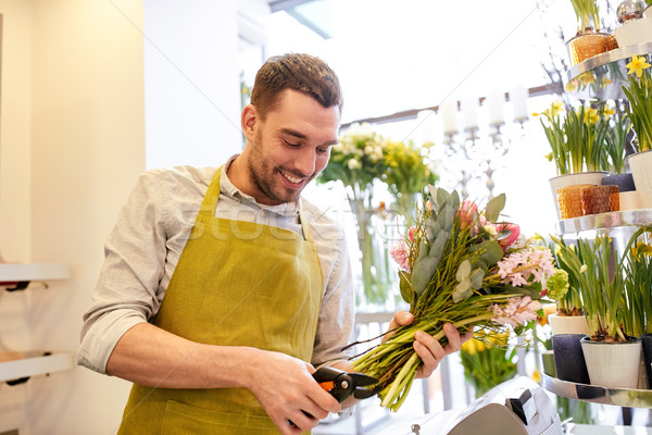 smiling florist man making bunch at flower shop Stock photo © dolgachov