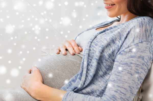 Stock photo: close up of happy pregnant woman at home