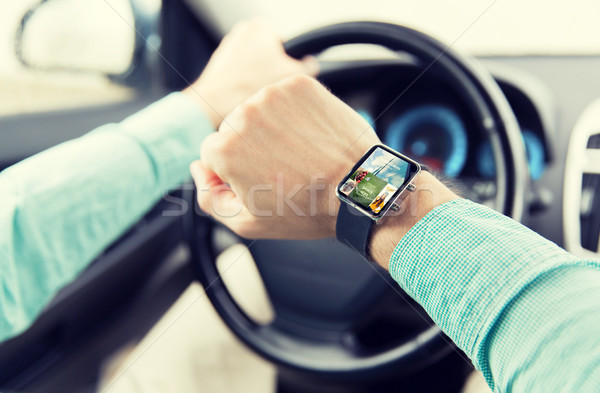 Stock photo: close up of male hands with smartwatch driving car