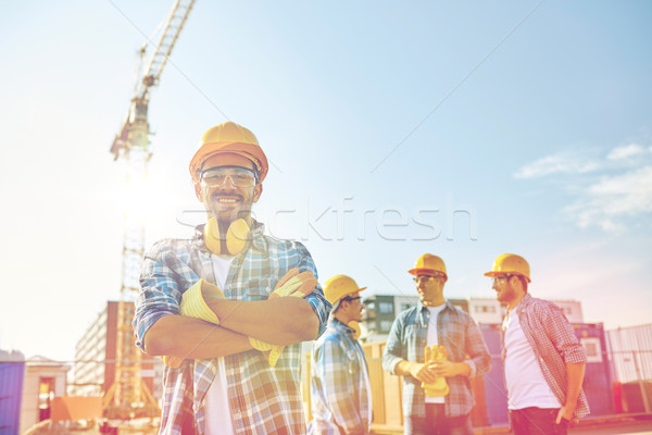 Stock photo: group of smiling builders in hardhats outdoors