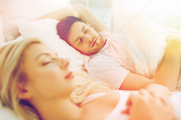 happy couple sleeping in bed at home Stock photo © dolgachov