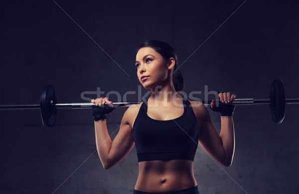 Jonge vrouw spieren barbell gymnasium sport fitness Stockfoto © dolgachov