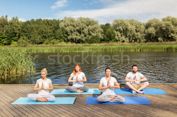 people meditating in yoga lotus pose outdoors Stock photo © dolgachov