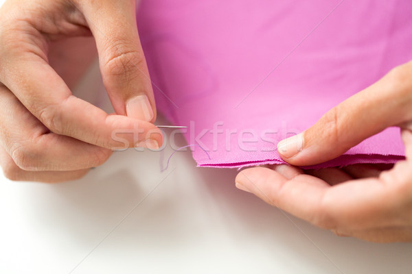 woman with needle stitching fabric pieces Stock photo © dolgachov