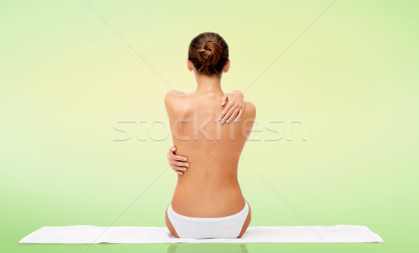 beautiful topless young woman on towel from back Stock photo © dolgachov