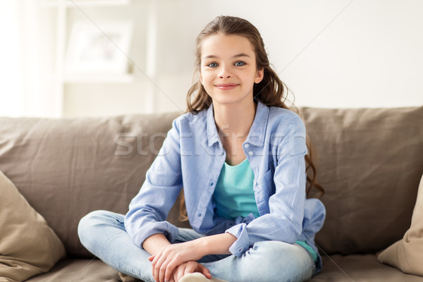happy smiling preteen girl sitting on sofa at home Stock photo © dolgachov