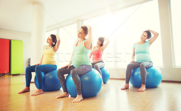 happy pregnant women exercising on fitball in gym Stock photo © dolgachov