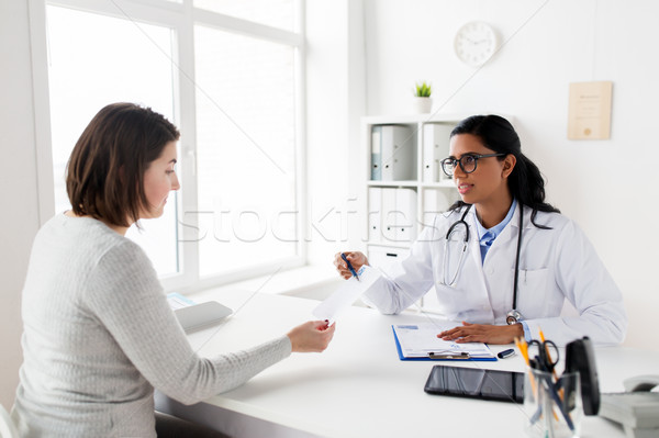 doctor with clipboard and woman patient at clinic Stock photo © dolgachov